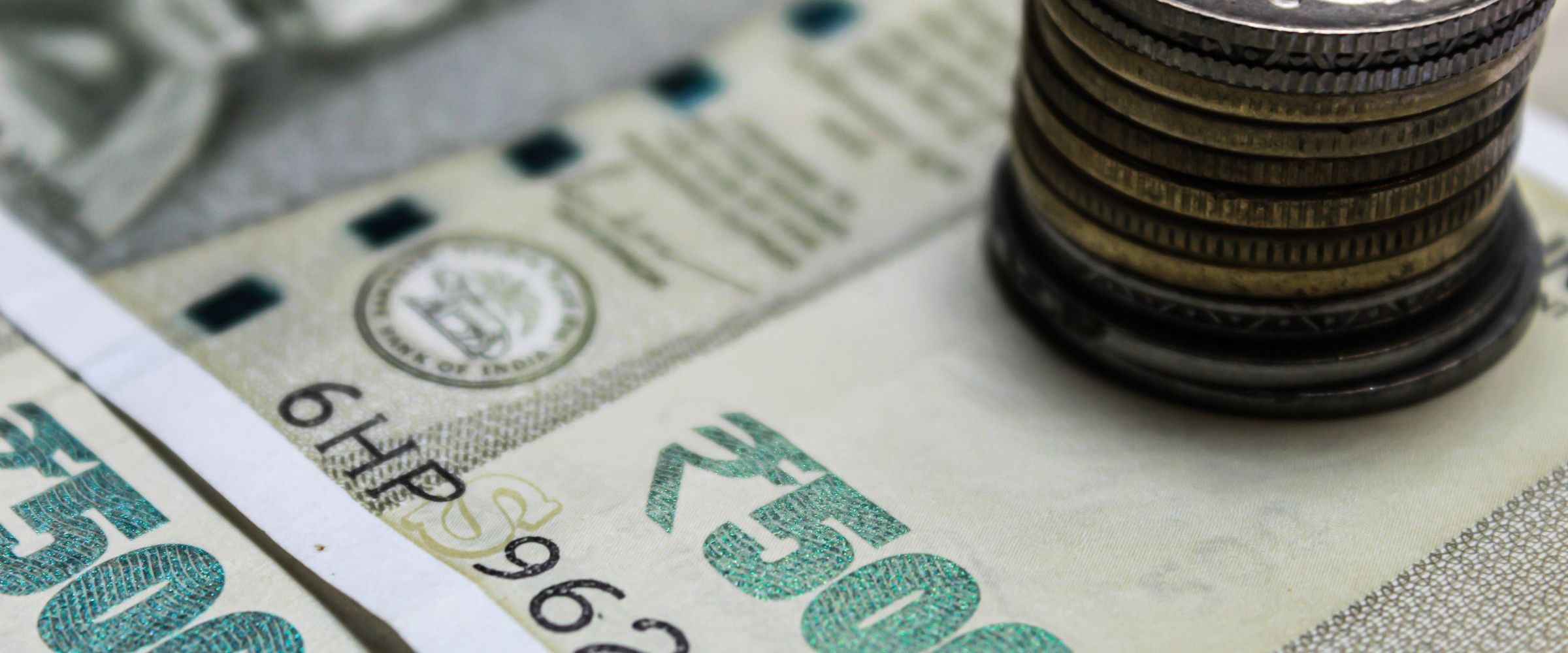 Indian rupee banknotes with a stack of coins